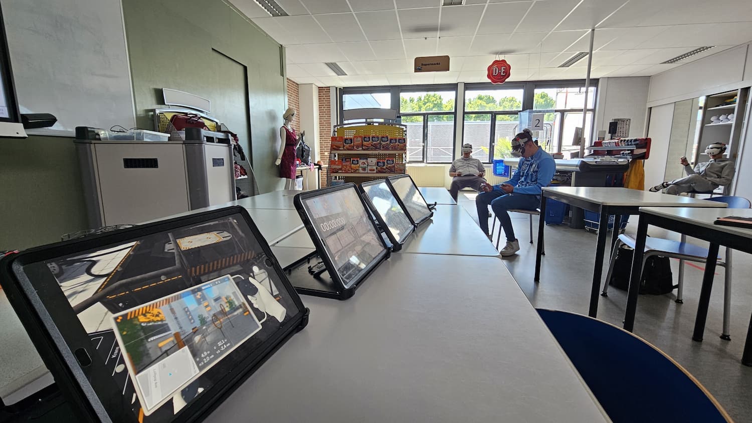 VR drone flight sessions in a classroom setting using Drone Simulator VR, with tablets displaying real-time views for teachers to observe and guide students